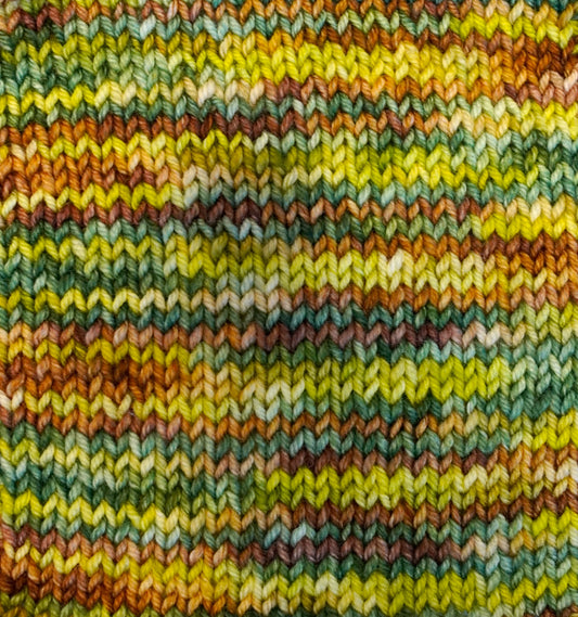 Swatch of various greens and browns and yellows knitted.