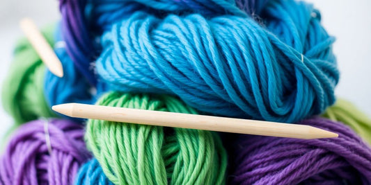 Colorful yarn skeins with knitting needles.