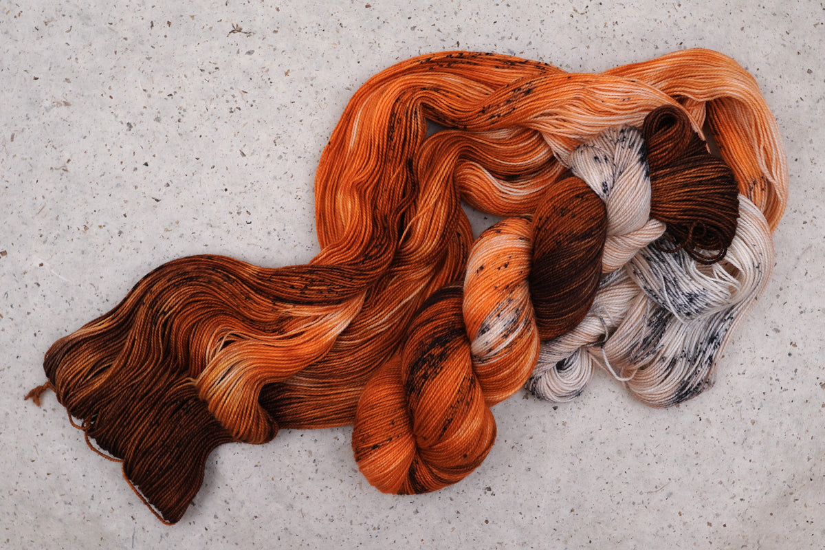 Wild Woollys Autumn Mocha yarn, an unwound skein showing brown, orange, and cream with dark speckles