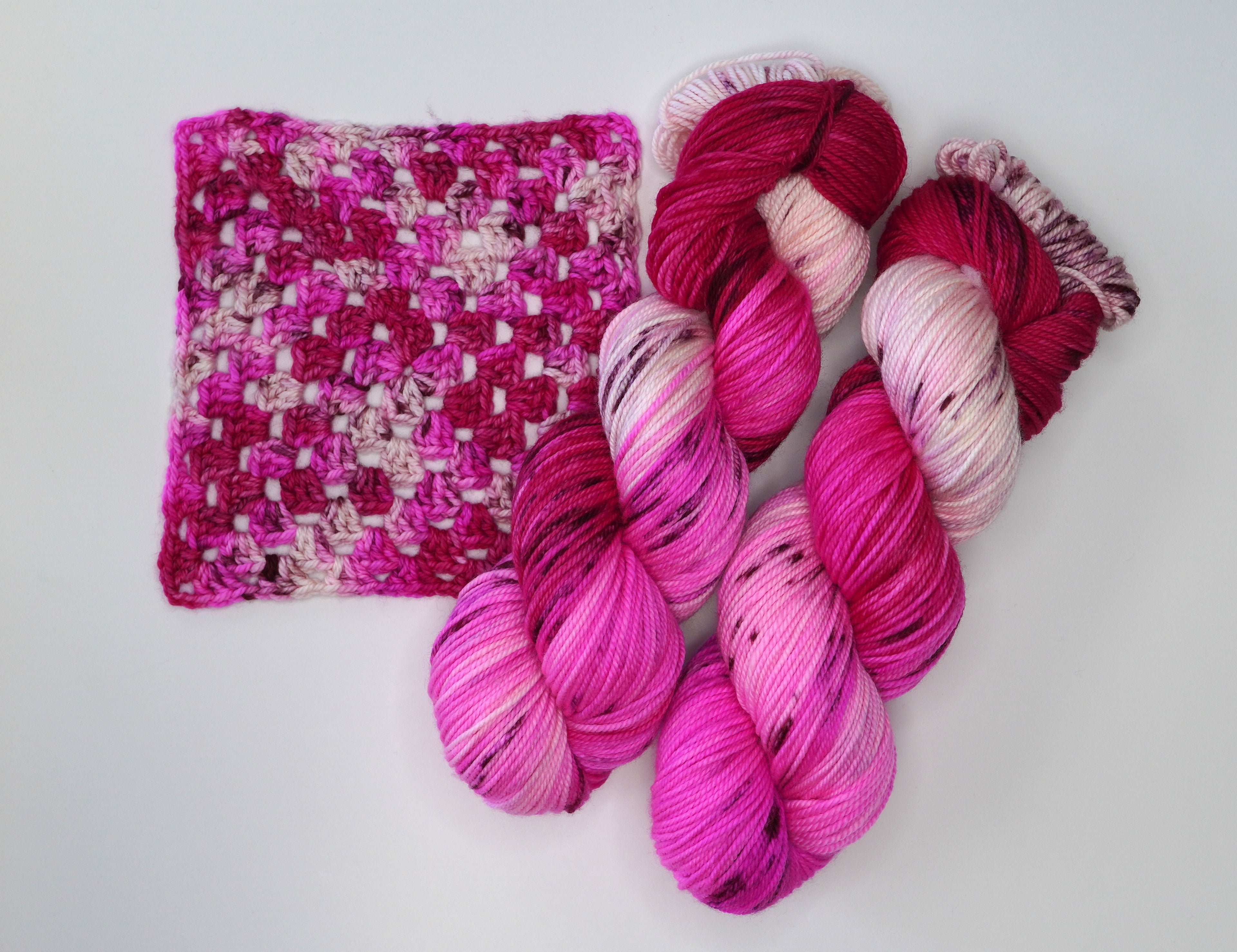 Wild Woollys Cherry Blossom yarn in skeins and a crocheted swatch