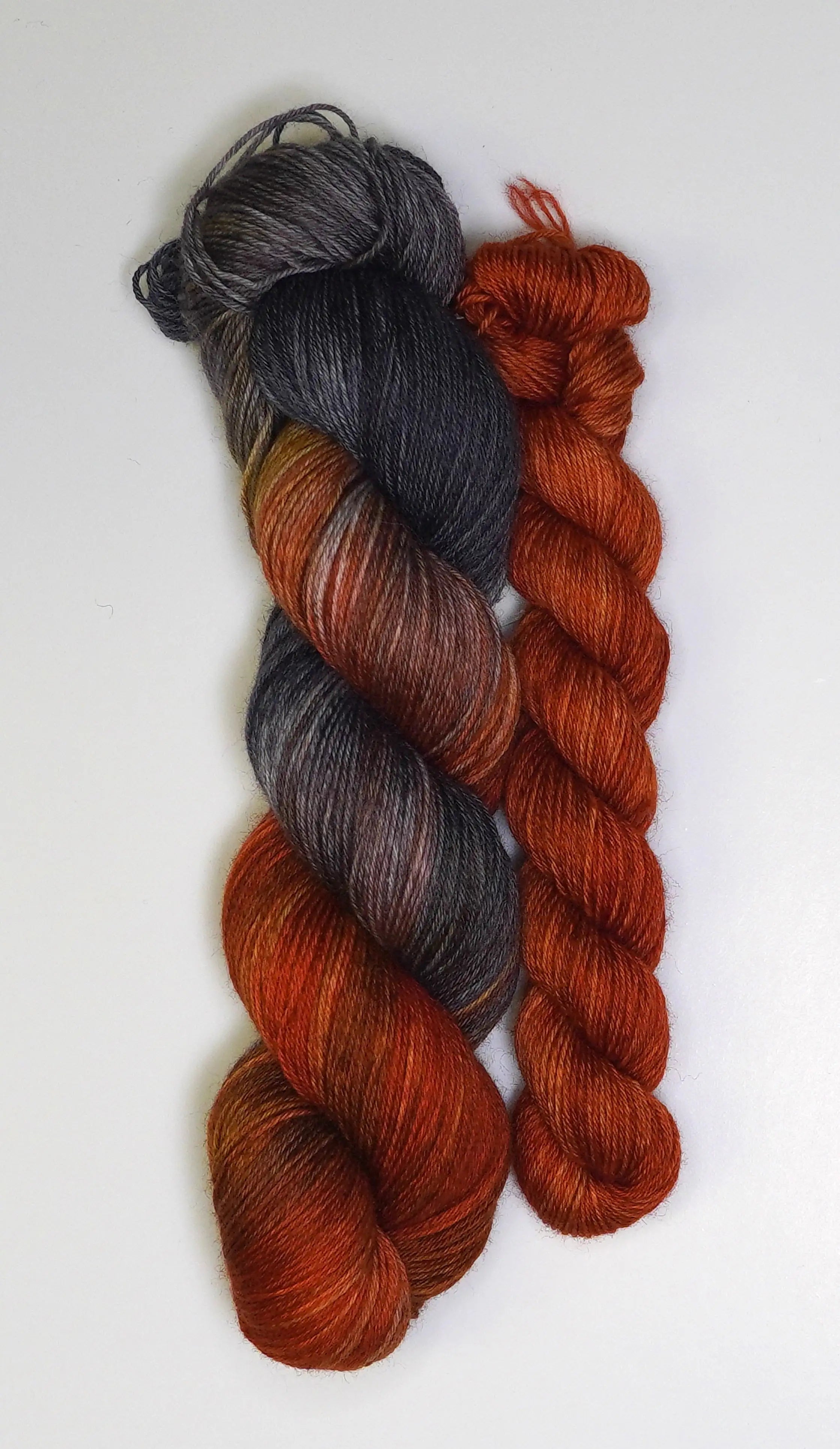 Wild Woollys Cobalt Rust Fingering Sock Set, one skein variegated dark grey to rust, one skein solid rust