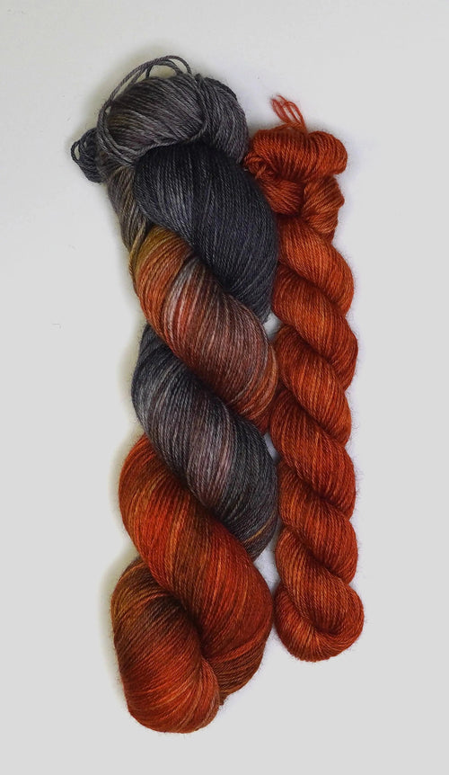 Set de calcetines Fingering Cobalt Rust de Wild Woollys — una madeja multicolor del gris oscuro al color óxido y una madeja lisa color óxido