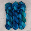 Wild Woollys Cerulean Rhapsody Fingering yarn, three skeins in teal, turquoise, and deep blue