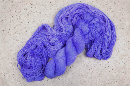 Hilo Crocus Pocus de Wild Woollys, una madeja desplegada en tonos azul vinca y violeta