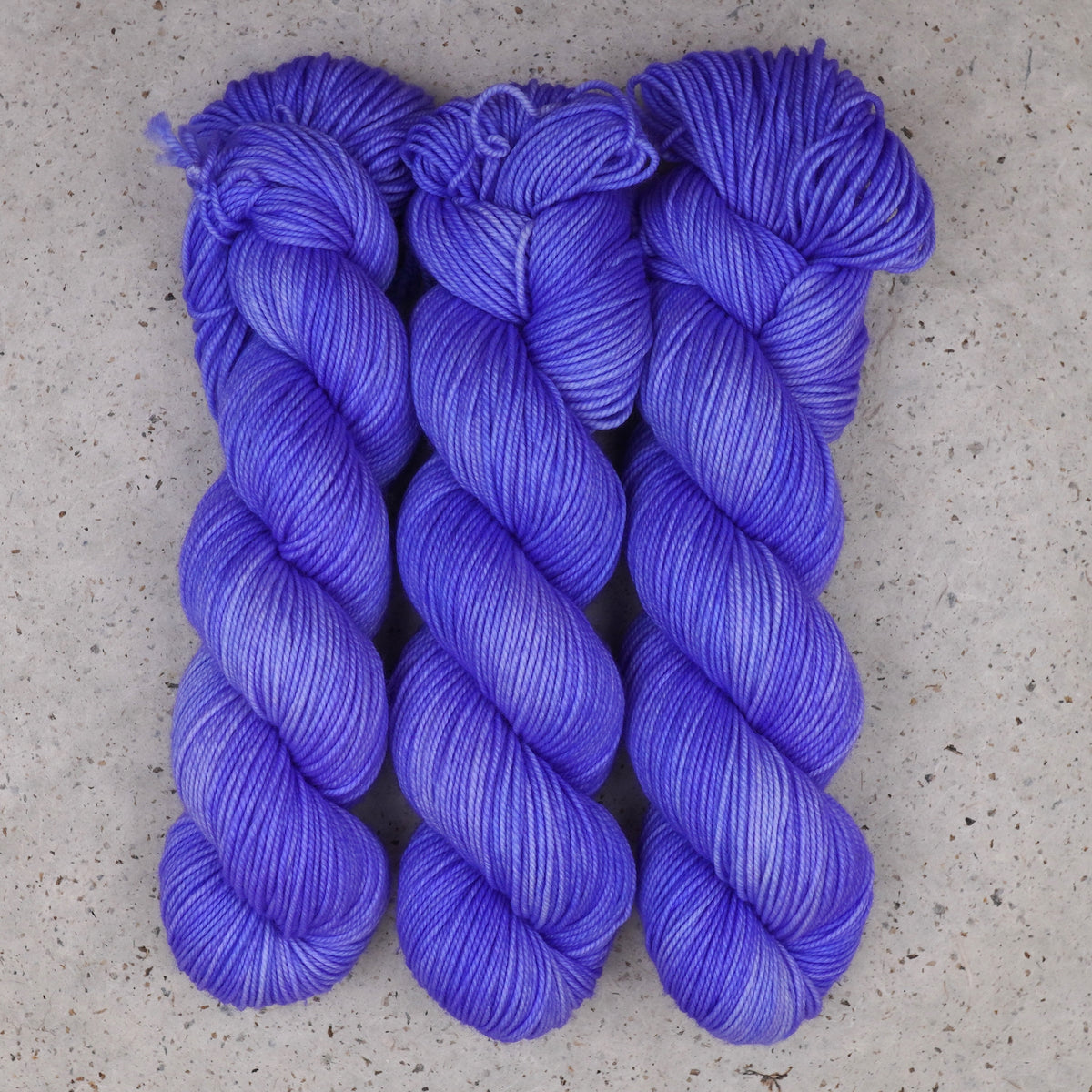 Wild Woollys Crocus Pocus DK yarn, three skeins in periwinkle and violet purple