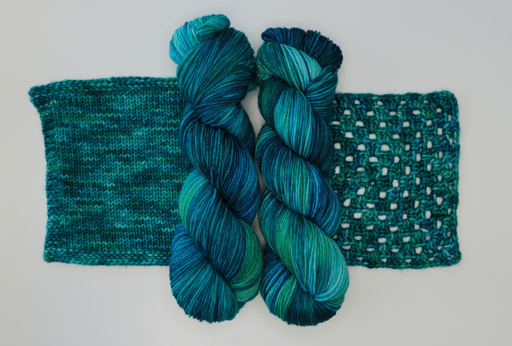 Wild Woollys Cerulean Rhapsody yarn, two skeins and two knitted swatches in blue and green