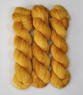 Three skeins of Wild Woollys Hayday yarn in a bright yellow color