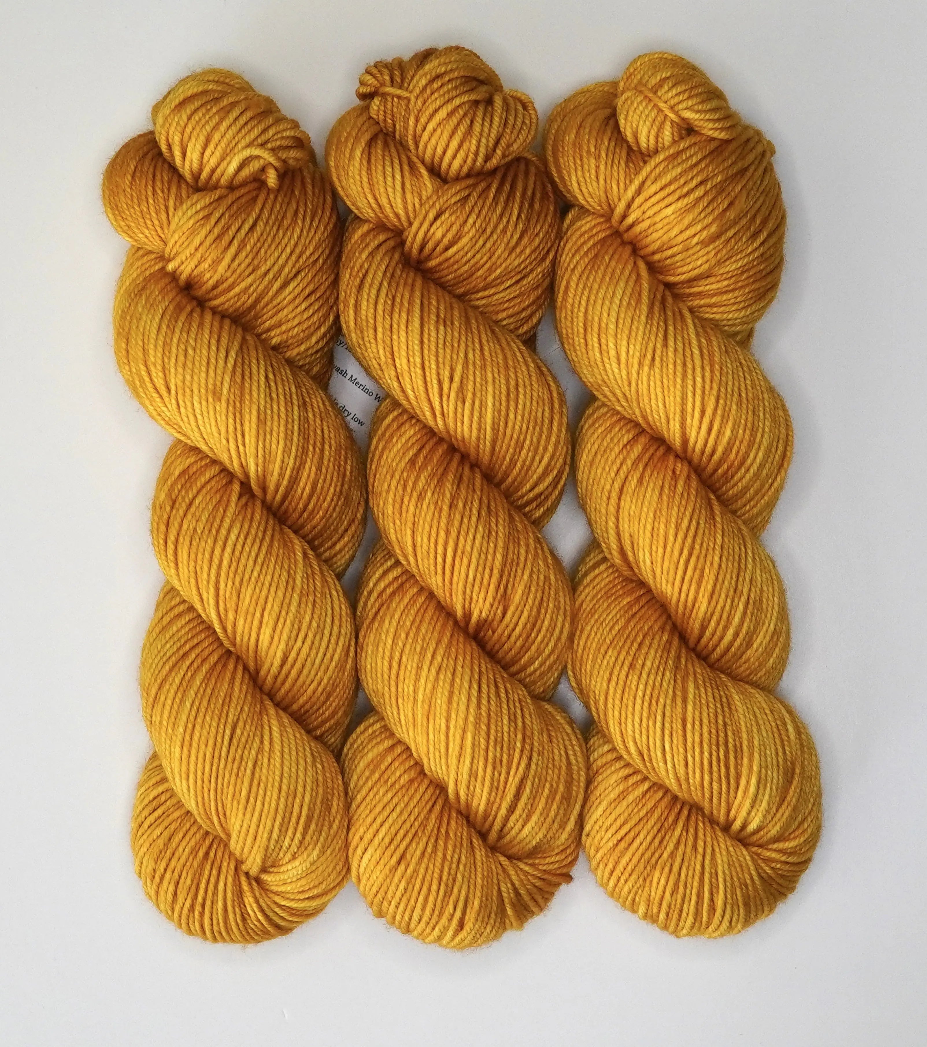 Wild Woollys Hayday yarn in three skeins of golden yellow