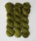 Three skeins of Wild Woollys Fiddlehead Fern yarn, a deep olive green color, on a white background