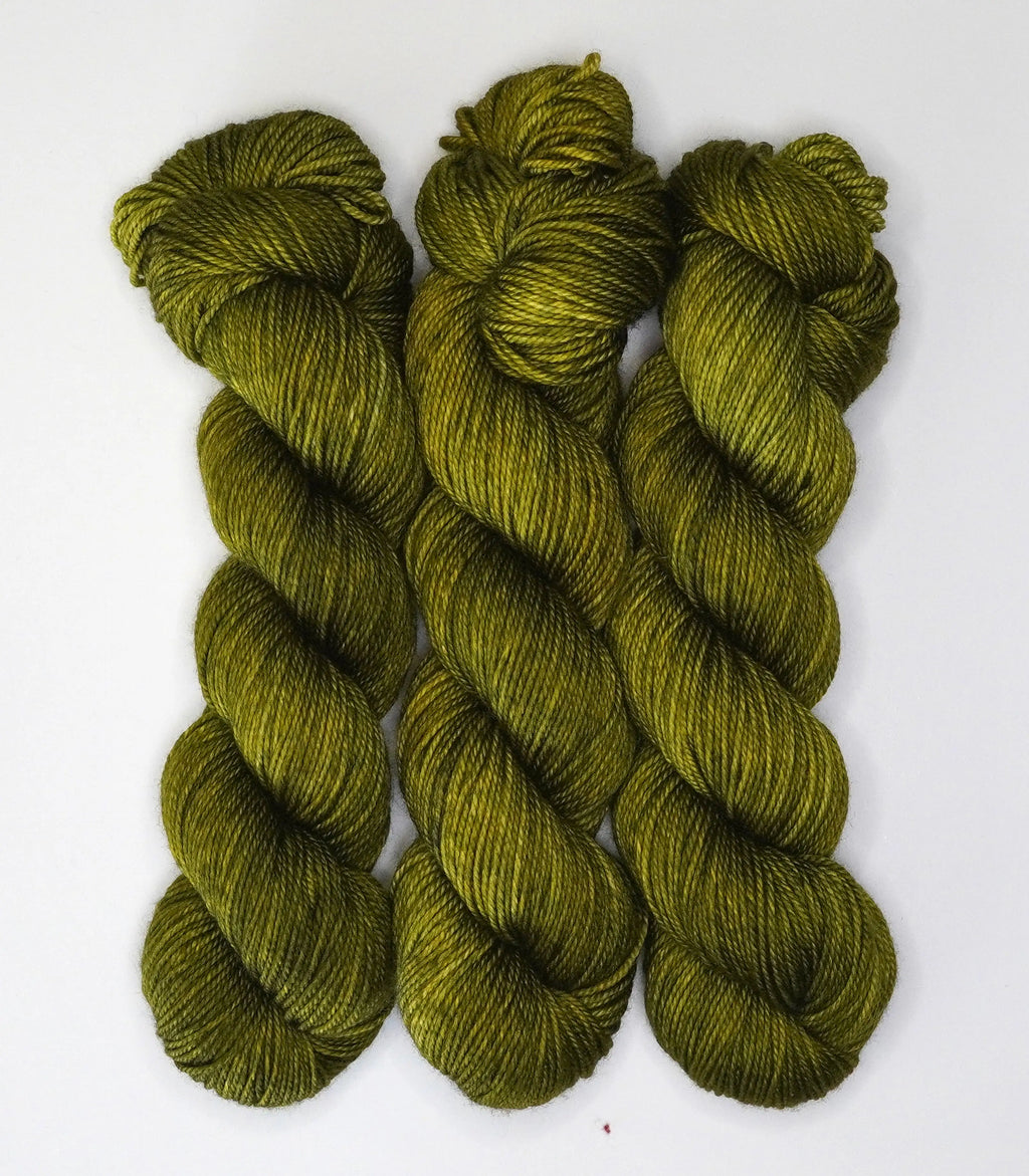 Wild Woollys Fiddlehead Fern yarn, three skeins of dark green yarn with yellow undertones