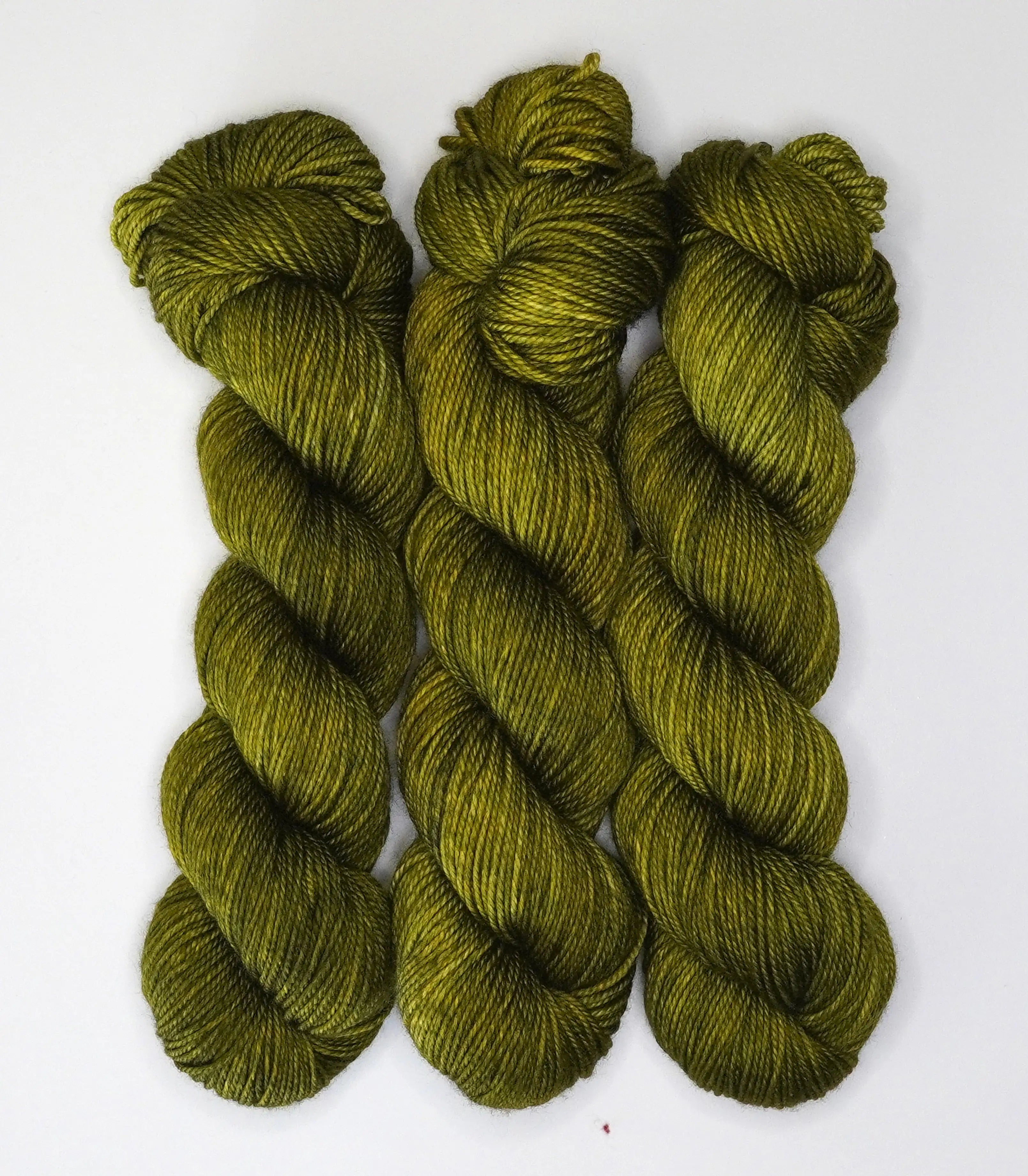Wild Woollys Fiddlehead Fern yarn, three skeins of dark green yarn with yellow undertones