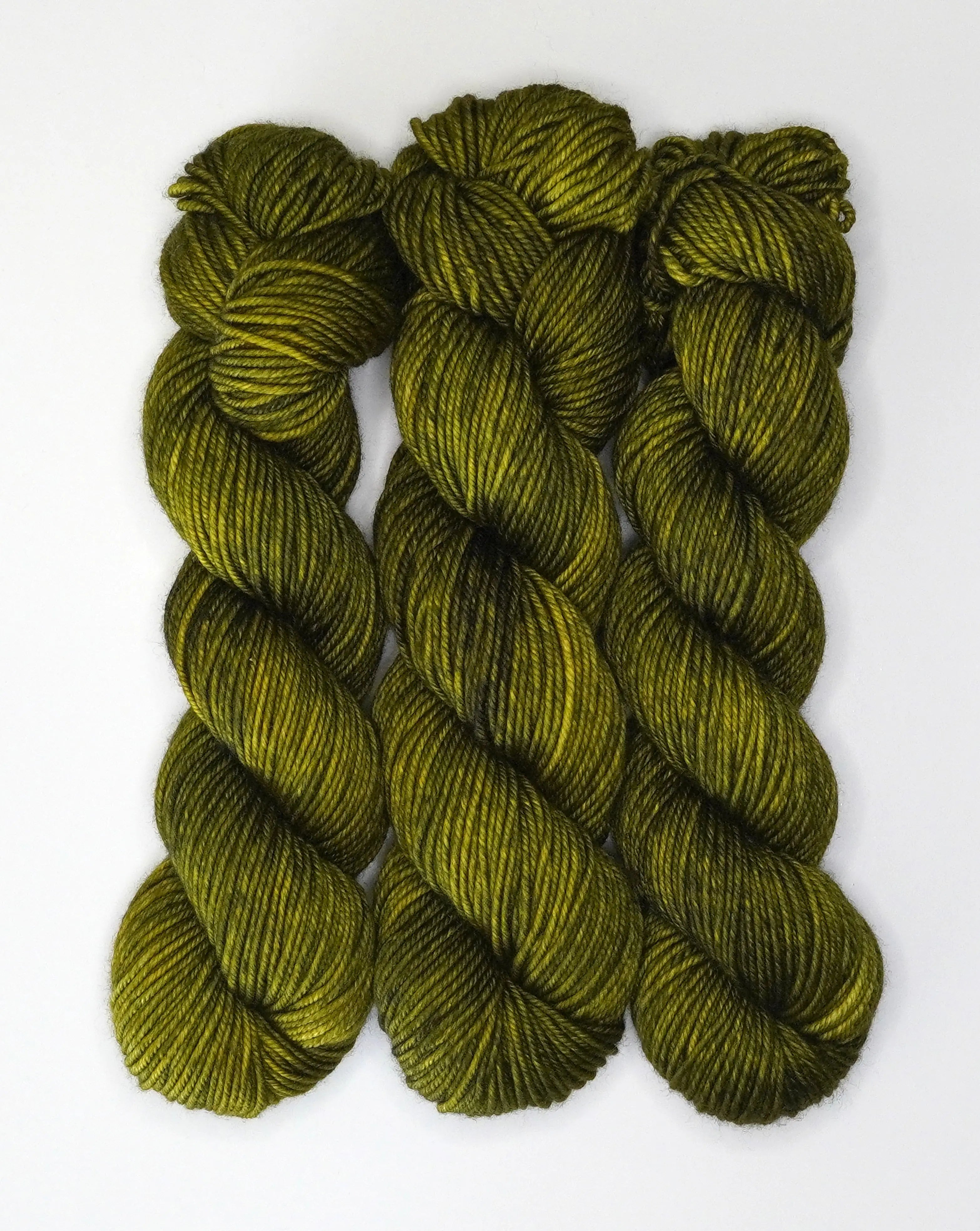 Wild Woollys Fiddlehead Fern yarn, three skeins of dark green and yellow yarn