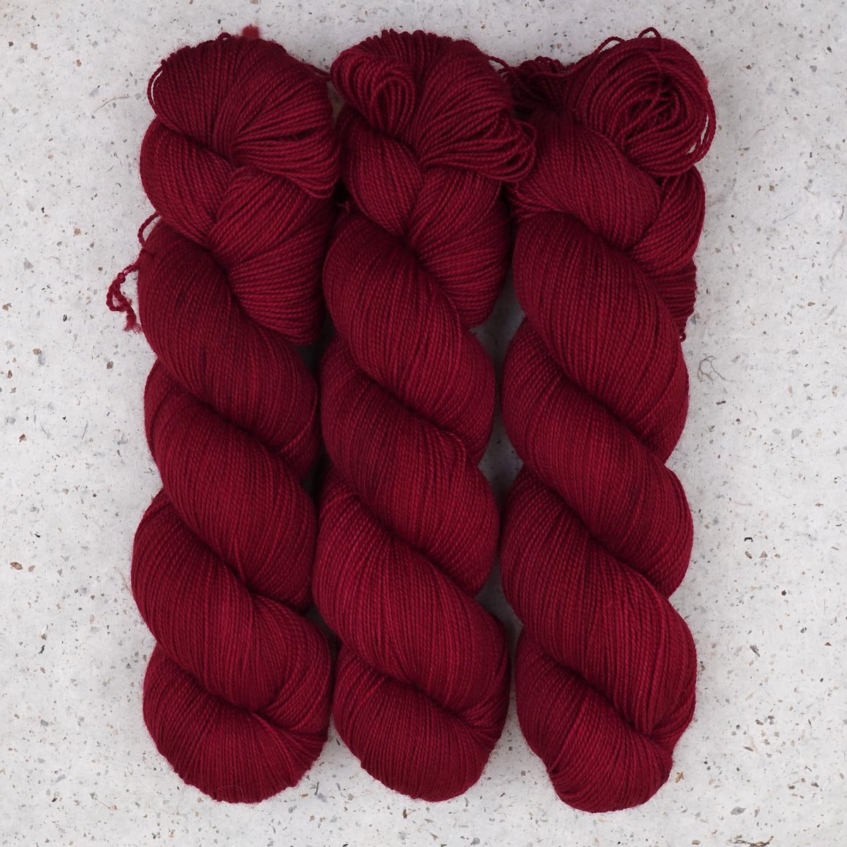 Wild Woollys Divine Wine Fingering yarn, three skeins in deep burgundy red