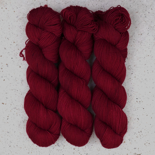 Hilo Divine Wine Fingering de Wild Woollys — tres madejas en rojo burdeos intenso