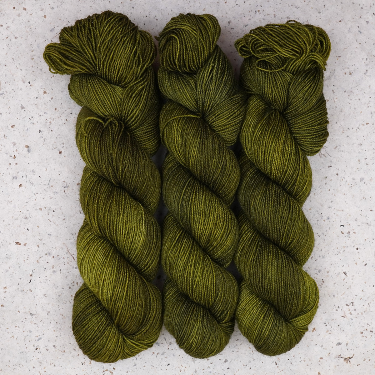 Wild Woollys Fiddlehead Fern Fingering yarn, three skeins in deep olive green