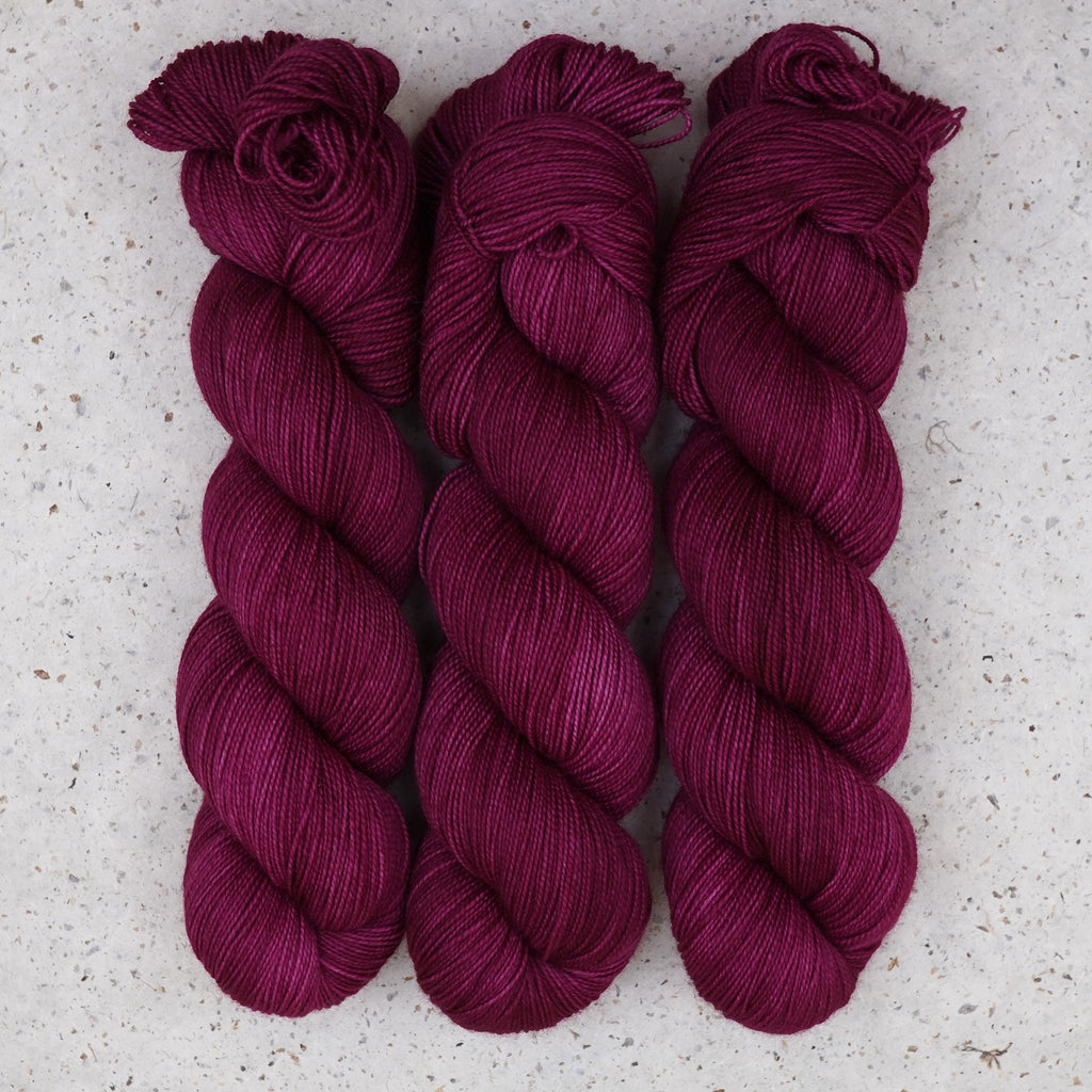 Fuchsia Nostalgia Fingering Garn von Wild Woollys — drei Stränge in tiefem Magenta und Beerenrosa