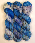 Wild Woollys Galaxy Voyage yarn in three skeins, blue, purple, and white with speckles