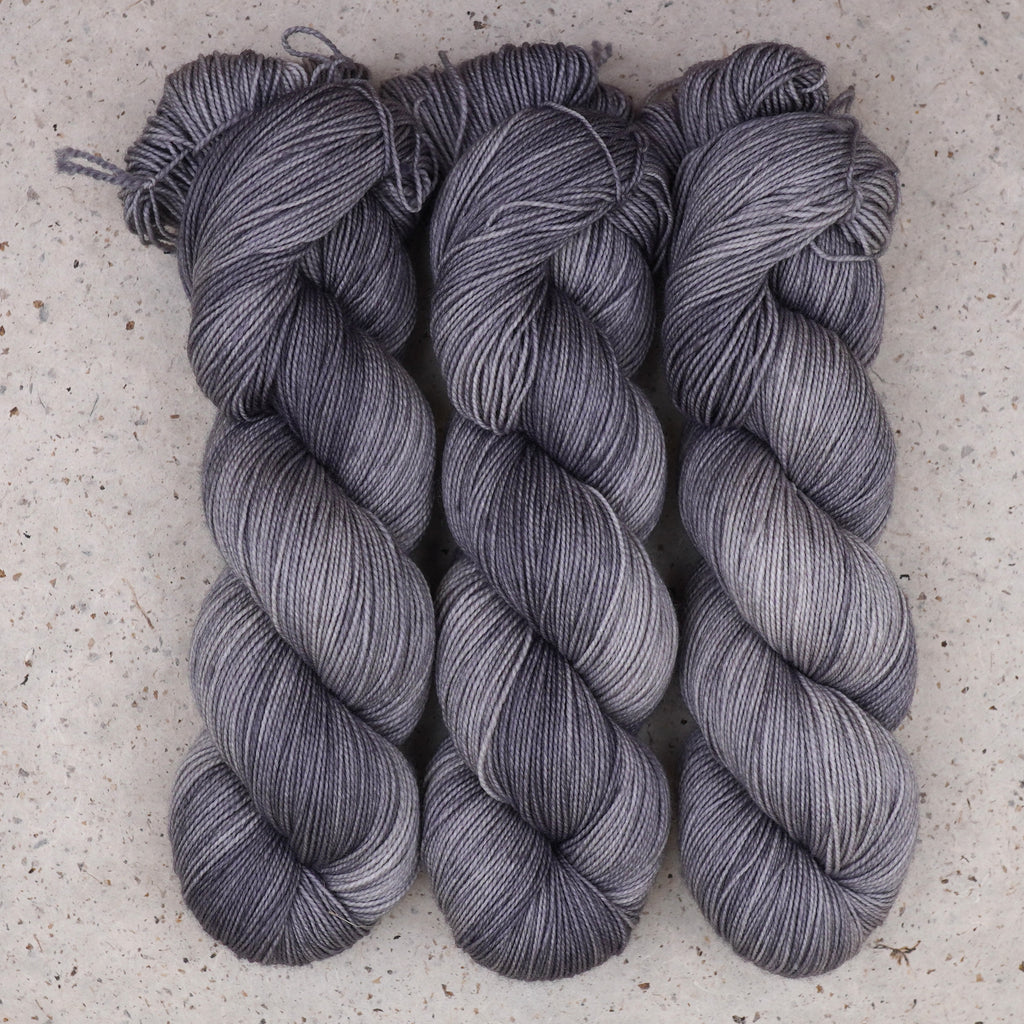 Hilo Grey Expectations Fingering de Wild Woollys — tres madejas en gris suave y plata