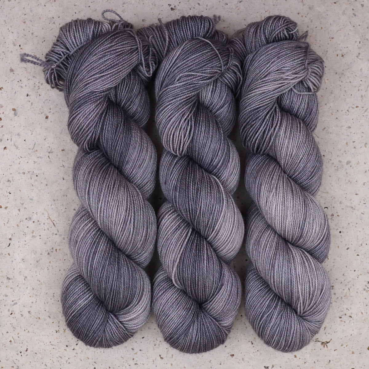 Wild Woollys Grey Expectations Fingering yarn, three skeins in soft grey and silver