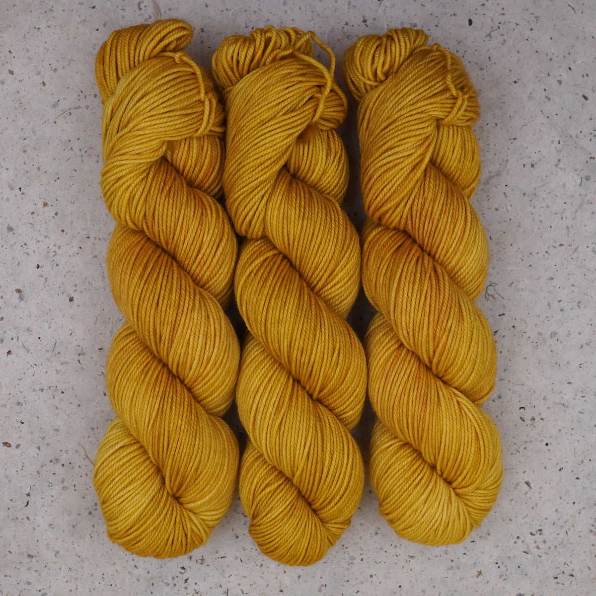 Wild Woollys Hayday DK yarn, three skeins in golden yellow and warm amber