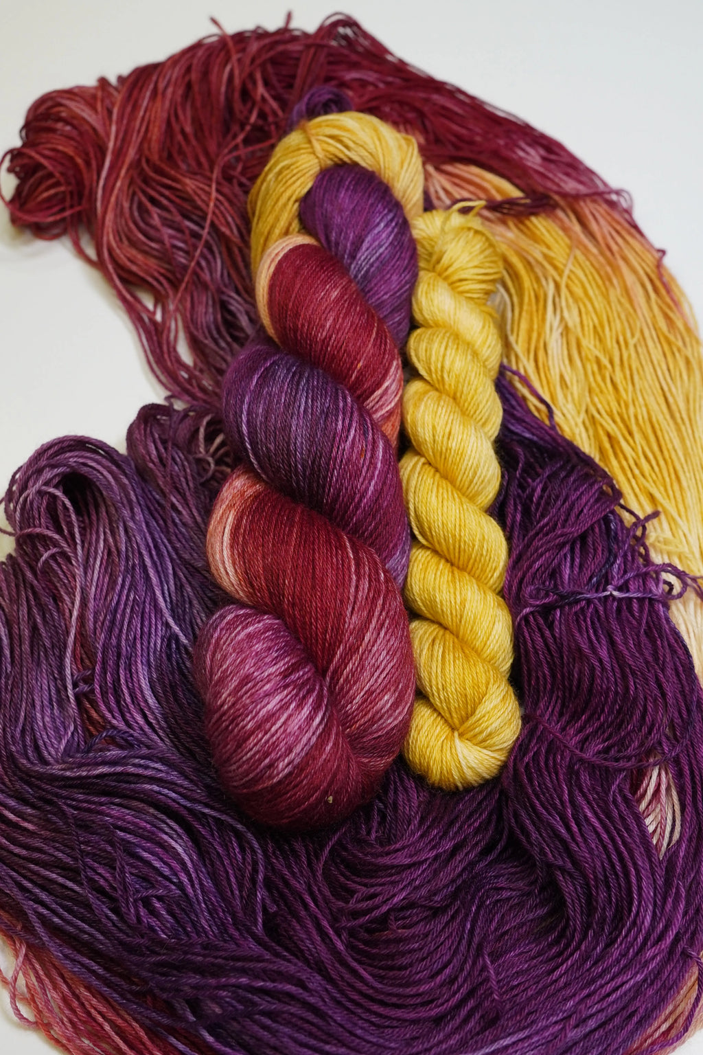 Wild Woollys Maizie Dayz Fingering Sock Set yarn in red, purple, and yellow