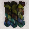 Fil Mycelium Bloom Fingering de Wild Woollys — trois écheveaux aux tons vert olive, brun foncé et bleu canard profond