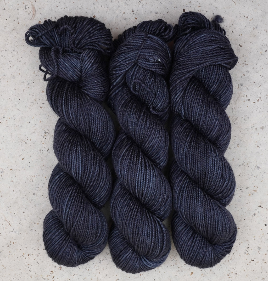Hilo Obsidian Nights DK de Wild Woollys — tres madejas en azul marino casi negro y gris carbón