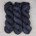 Hilo Obsidian Nights Fingering de Wild Woollys — tres madejas en azul marino casi negro y gris carbón