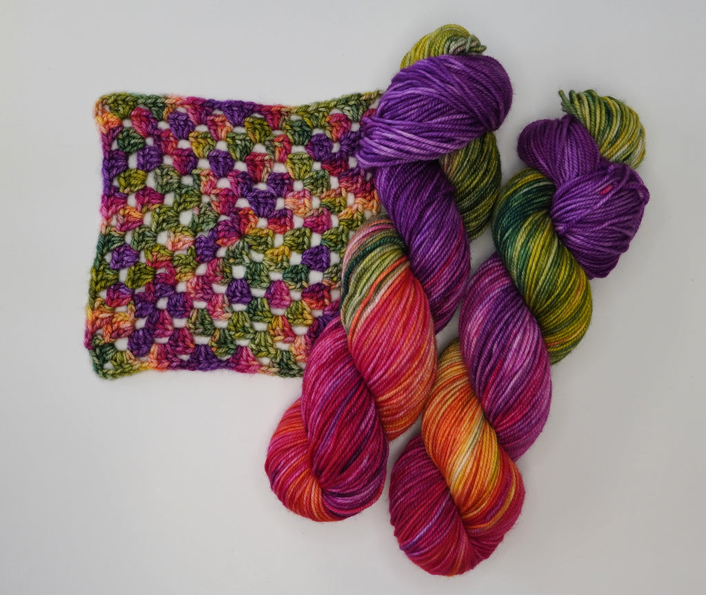 Wild Woollys Summer Berry yarn with a crocheted swatch in shades of pink, purple, green, and orange