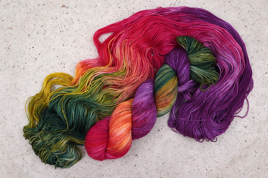 Fil Summer Berry de Wild Woollys — un écheveau déroulé aux tons magenta, violet, corail et rose