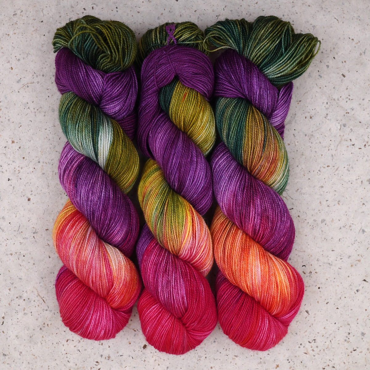 Wild Woollys Summer Berry Fingering yarn, three skeins in magenta, purple, coral, and pink