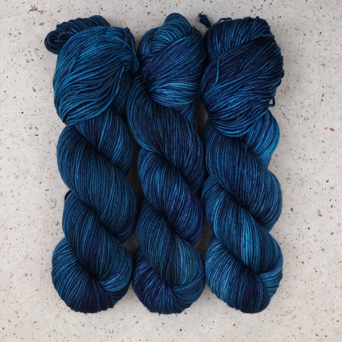 Wild Woollys Teal of Fortune DK yarn, three skeins in deep teal and blue