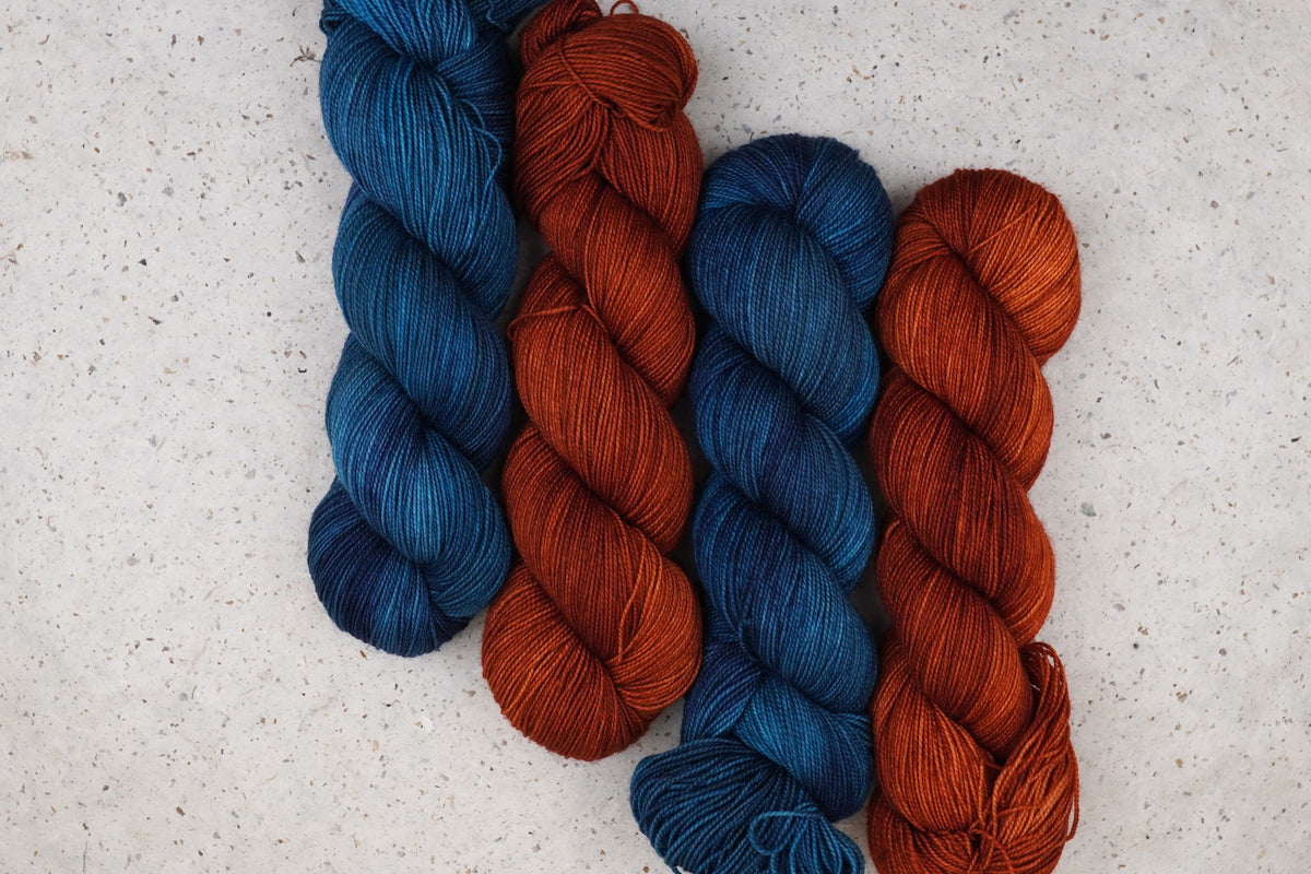 Wild Woollys Teal of Fortune yarn in deep teal and blue paired with Penny Laine yarn in rust orange