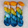 Hilo Tropical Escape Fingering de Wild Woollys — tres madejas en amarillo dorado, crema, verde azulado y azul océano