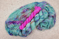 Wild Woollys Undersea Garden sock set, an unwound skein in soft mint green with purple and blue speckles with a contrasting hot pink mini-skein