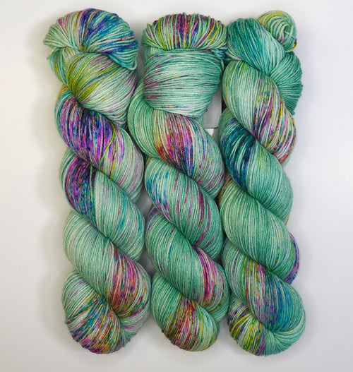 Wild Woollys Undersea Garden yarn, three skeins of variegated green, purple, and blue yarn