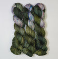 Wild Woollys Vintage Christmas Tree yarn, three skeins of dark green, light green, and white yarn