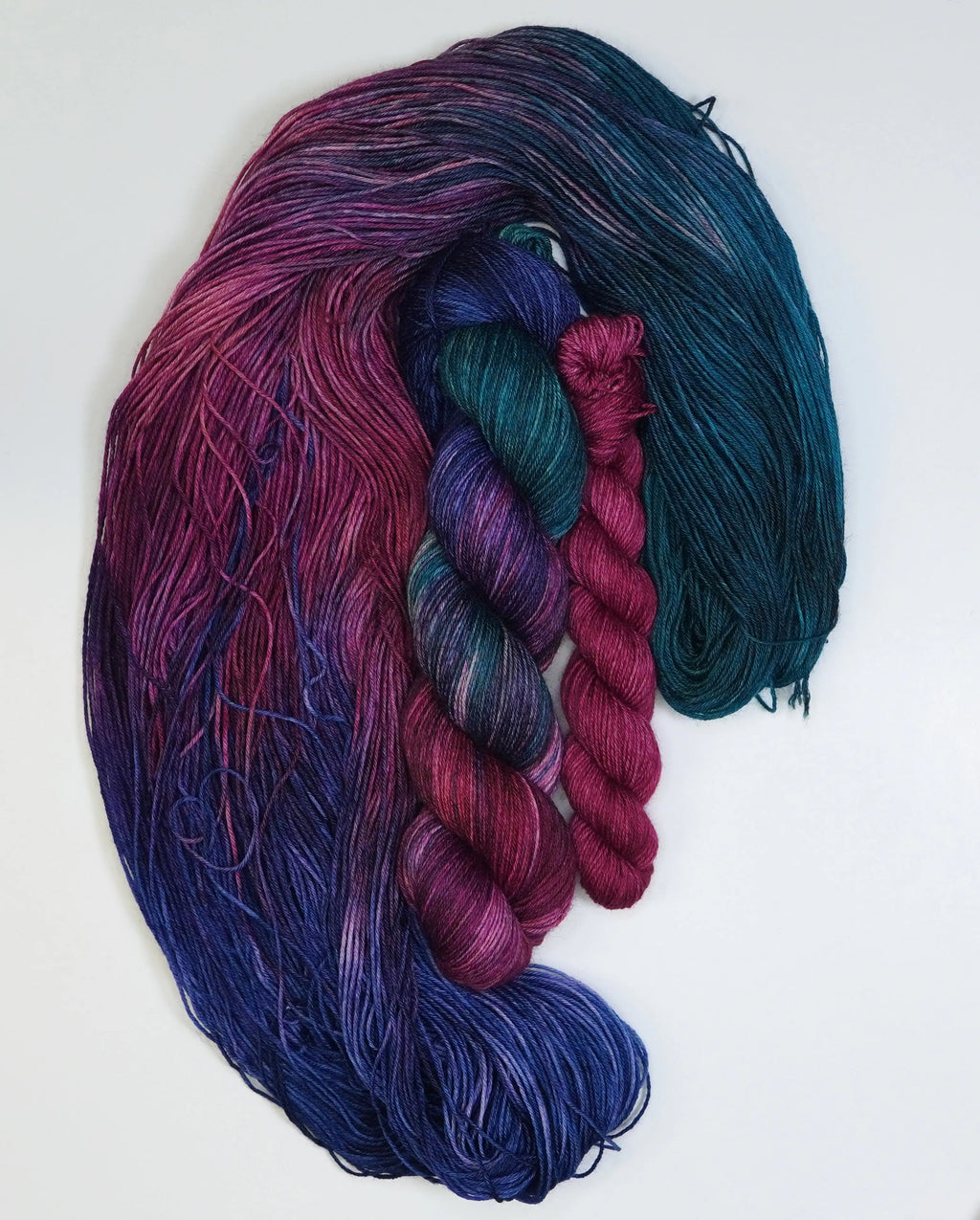 Wild Woollys Winter Aurora Fingering Sock Set with four skeins of yarn in shades of purple, blue, and teal