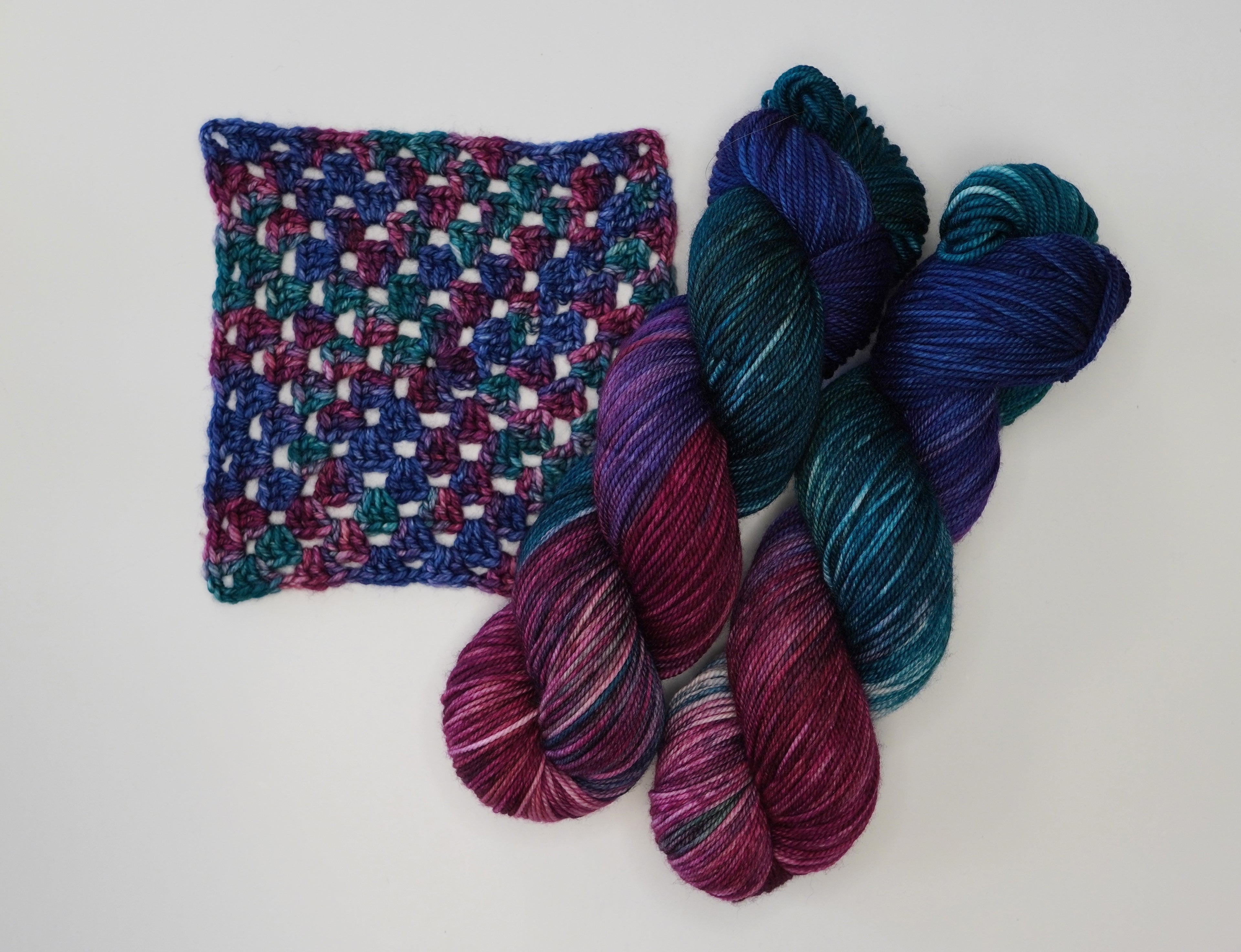 Wild Woollys Winter Aurora yarn and crochet swatch in shades of blue, purple, and teal