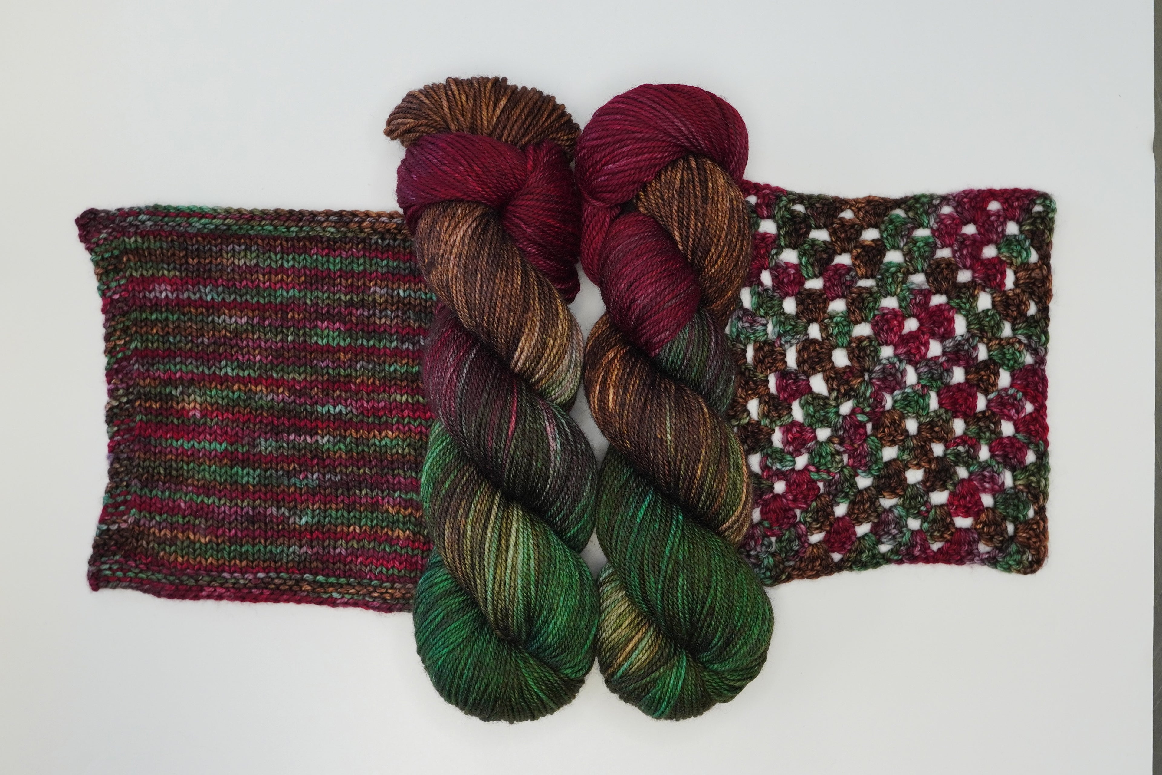 Wild Woollys Woodland Christmas yarn in two skeins and two swatches, one knit and one crocheted