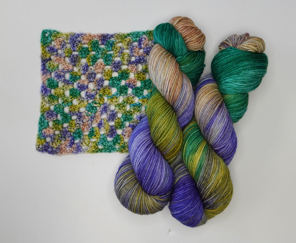Water Lilies yarn by Wild Woollys, with a crocheted swatch and two skeins of yarn